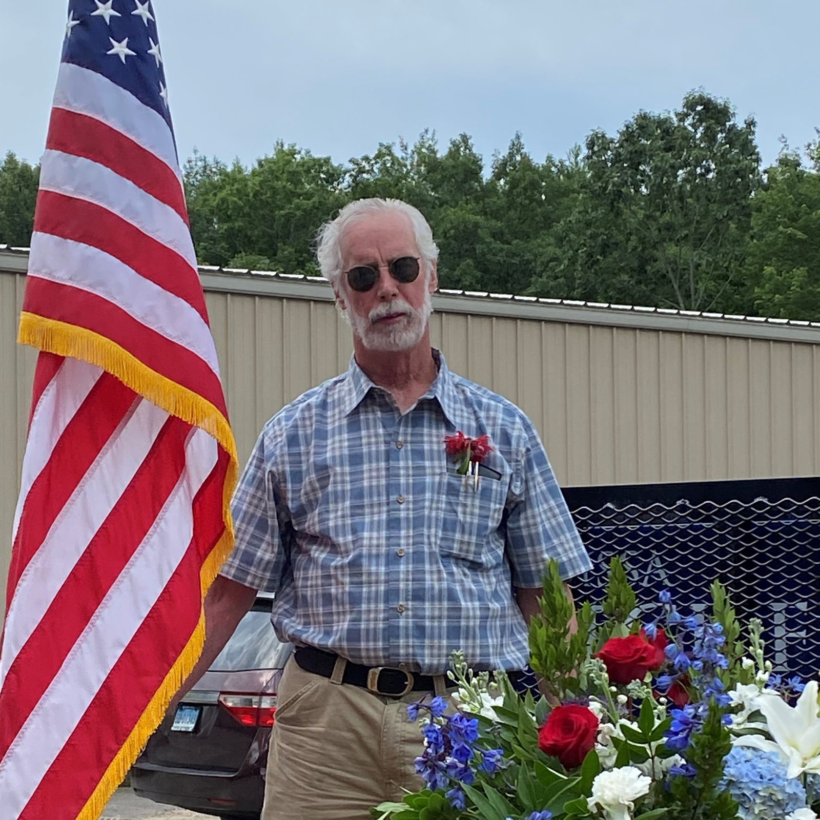 Larry Miner standing in front of an American flag