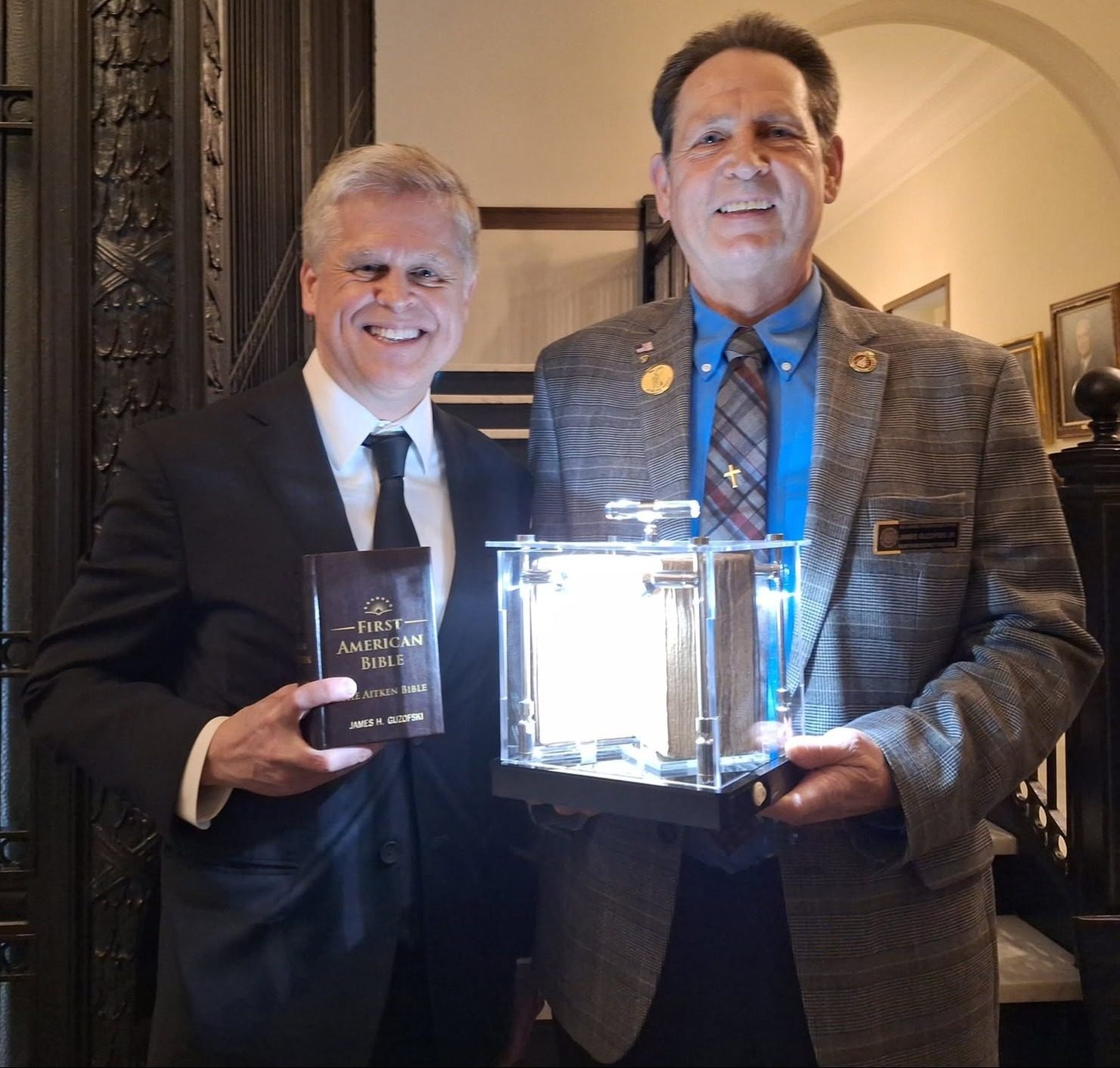 Jim Guzofski Jr. with a copy of the First American (Aitken) Bible at the State House